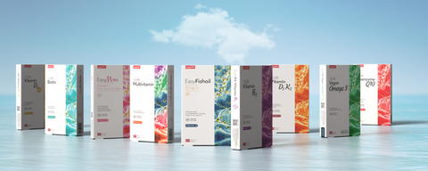 Blij kind dat vrolijk vitamines voor kinderen van EasyFishoil inneemt.